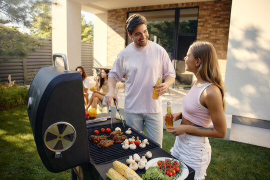 Friends enjoying summer barbecue party in backyard