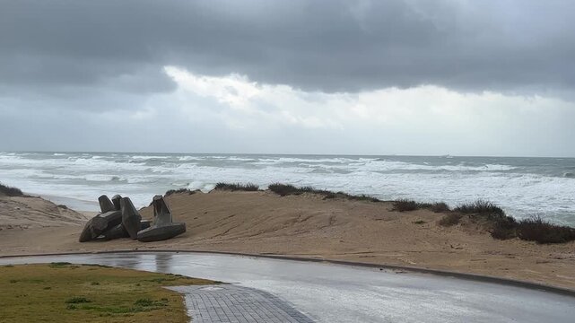 Stormy Mediterranean Sea in Ashkelon, Israel, with powerful waves, strong winds and heavy rain under dramatic dark clouds. Extreme winter weather along the coastline creating a cinematic and intense n