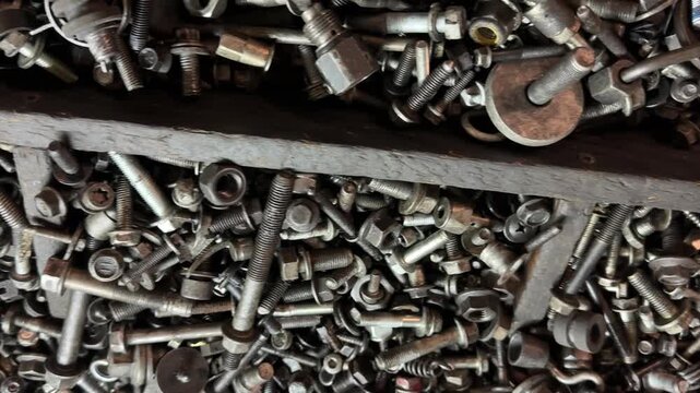 Close-up of metal screws and fasteners used in construction and industrial applications. Steel hardware components for assembly, engineering and mechanical installation. Concept of manufacturing, repa