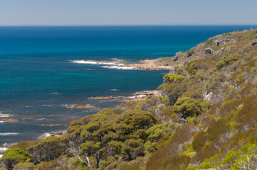 Fototapeta premium Natural seascape in Western Australia showing rugged shore, white surf and vibrant ocean colors under cloudless sky.