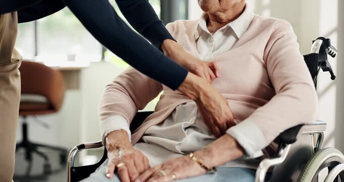 Hands, help and nurse dressing old woman in wheelchair for assisted living, healthcare or support. Buttons, getting dressed and senior person with disability in nursing home for medical assistance