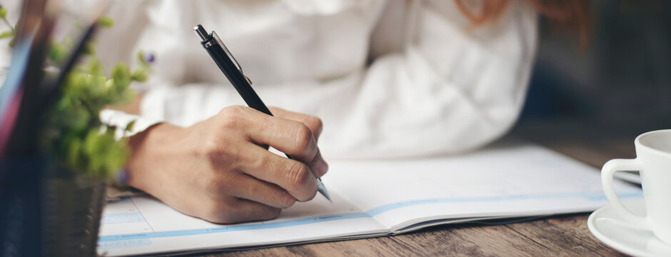 Planner plan Schedule Calendar and reminder agenda, work online at home. Women hand writing daily appointment and note holiday trip in diary at business office desk. Calendar reminder event concept.