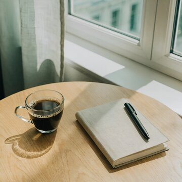 cup of cofee and notebook on the table, aesthetic view