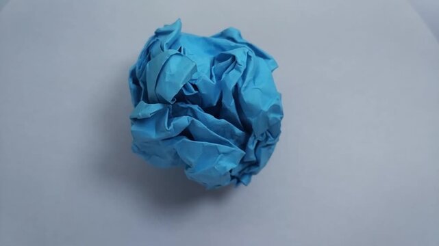 close up of a vibrant crumpled paper ball, symbolizing a discarded idea, mistake, or creative block.