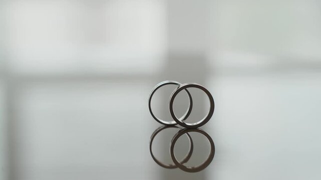 Wedding gold rings captured from an unusual angle, slow motion. Contemporary style