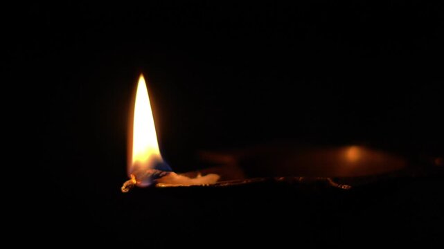Burning Oil Lamp Flame in Dark Background &ndash; Spiritual Diwali Concept. Traditional Diya with Glowing Flame &ndash; Peace and Spirituality Theme. Single Oil Lamp Burning in Darkness.
