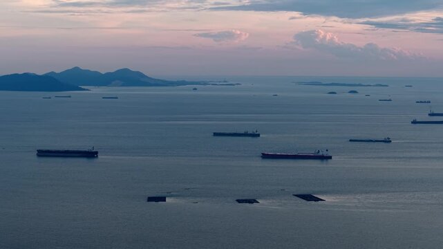 Aerial shot of ship crossing Straits of Malacca near coastal horizon.