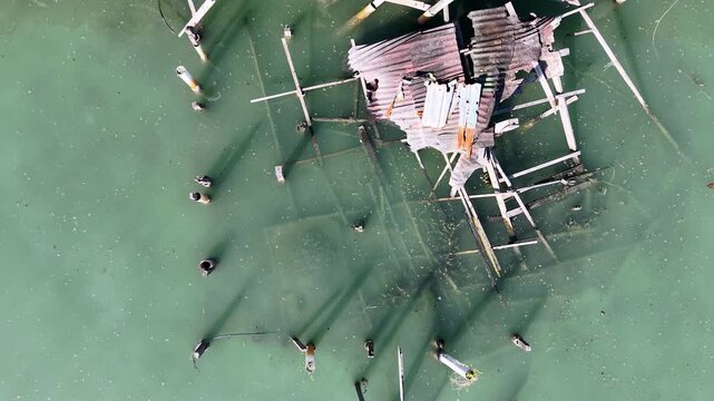 Aerial drone overhead view of broken wooden stilt house