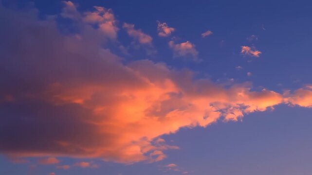 Sunset clouds painted in shades of orange and pink against a vibrant blue sky