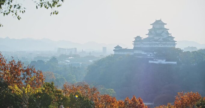 Cinematic shot of hazy Japanese valley and 16th century crow castle during autumn season