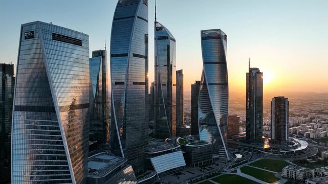 Modern skyscrapers with reflective glass facades and unique architectural designs illuminated by sunset in a vibrant urban skyline