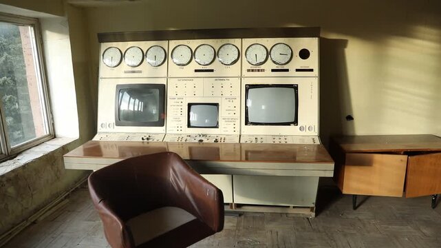 The camera slowly moves forward into an abandoned sunlit room featuring a vintage Soviet control panel with analog dials, old CRT monitors, and a single brown leather chair.


