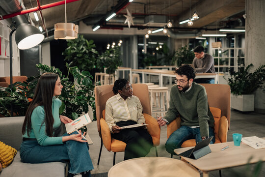Diverse business team collaborating in modern office lounge