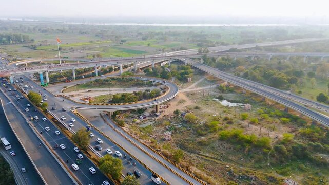 Top down cross traffic highway with cars, trucks aerial. Urban transportation at bridge road at Delhi. Cinematic cityscape of downtown freeway drone shot. Noida Freeway.