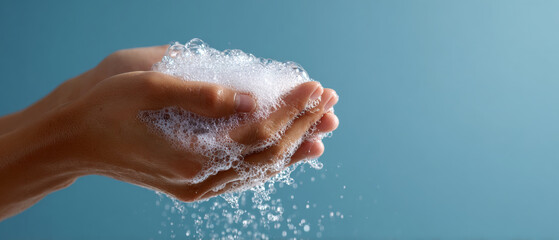 Fototapeta premium Hands holding soap foam with water droplets
