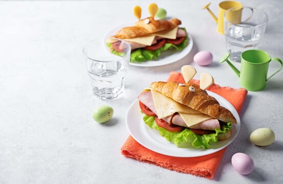 Croissant sandwich with ham, tomato and cheese in the form of rabbit for Easter holidays