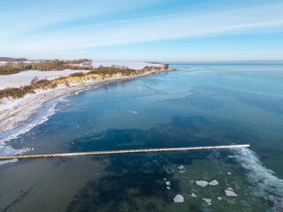 Aerial drone view of a frozen Baltic Sea coastline during winter.