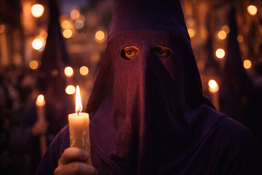 Nazareno penitent holding a burning candle during Holy Week Spanish procession (Semana Santa)