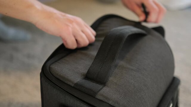 Photographer unzipping a padded camera bag