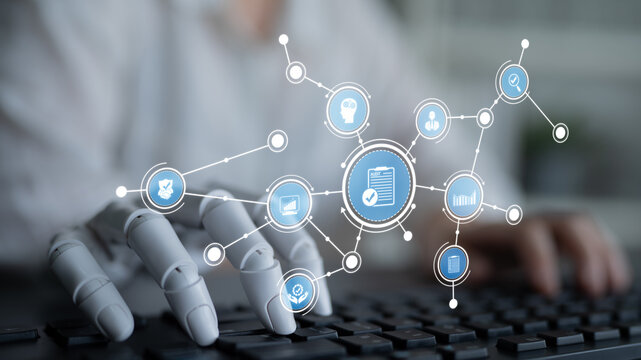 A robotic hand interacts with digital data icons above a keyboard, symbolizing advanced technology and artificial intelligence in a modern workspace environment. Tessel