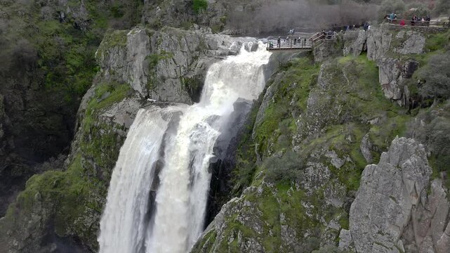 Aerial view of Pozo de los Humos waterfall in Salamanca, Spain, located in Arribes del Duero Natural Park. Dramatic 50-meter cascade of the Uces River surrounded by granite cliffs and wild landscape.