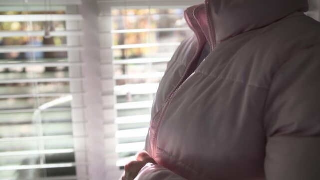Woman zipping up pink puffer jacket