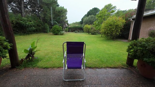 Empty purple folding chair in the rain