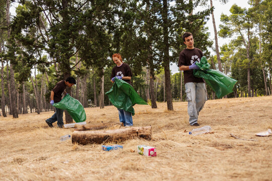 Young volunteers cleaning up forest for nature preservation