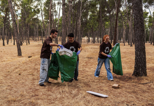 Young volunteers cleaning forest for recycling initiative