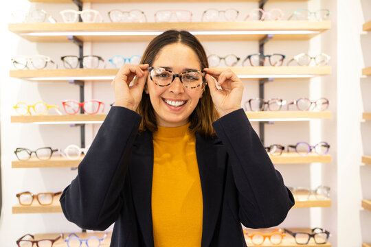 Woman trying on glasses in optical store