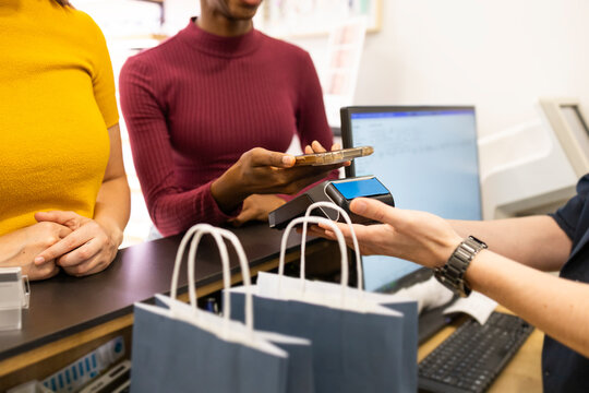 Customer making mobile payment in optical store