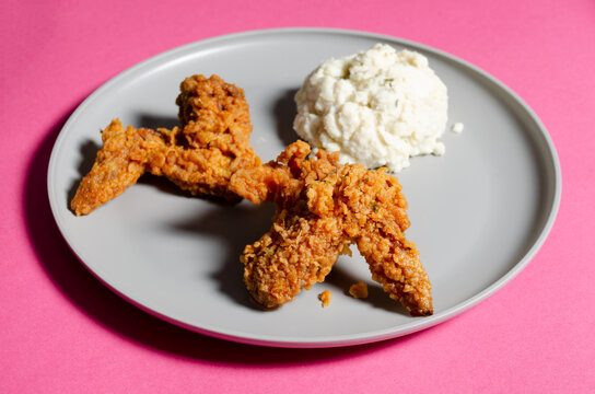 Crispy chicken wings with mashed potatoes on gray plate