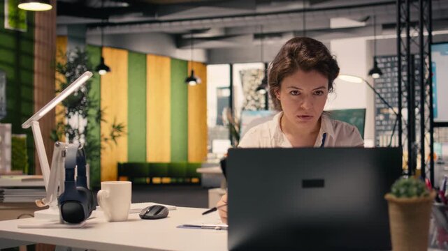 Businesswoman focused on writing detailed report at office desk, summarizing updates, organizing the agenda and drafting insights for the task management plans. Strategic planning.