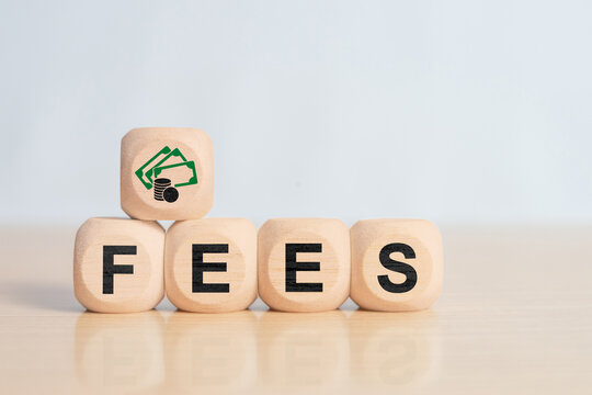 Wooden blocks spelling fees with money icon on top. Concept of service charges, transaction costs, banking fees, administrative expenses, financial obligations and business cost management.