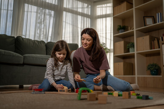 Mother and daughter playing with toy blocks together