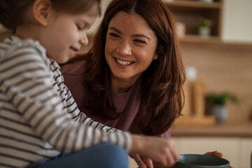 Mother and child preparing food together in kitchen