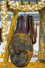 Dry meat and sausages hanging in local smokehouse interior