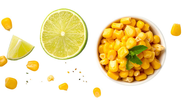 Composition of food with lime slices, kernel corn in a bowl and scattered kernels. Bright yellow and green colors on a black backdrop