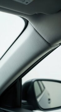 Interior view captures vehicle trim panel detail beside the windshield next to a side mirror.