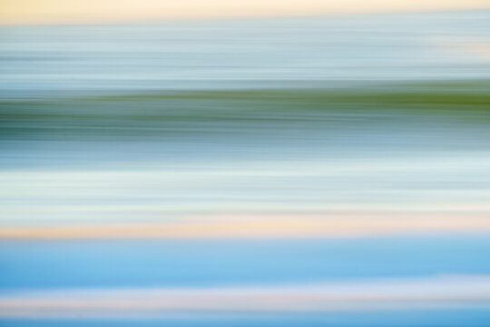 Sky and Ocean Abstract. Abstract photo of waves in smooth wave formation in low key blue and orange hues.