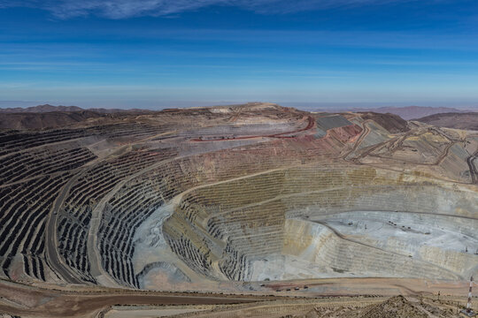 Panoramic view of a huge open-pit mine with hundreds of benches and mining roads