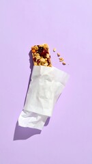 A partially unwrapped granola bar on a purple background (1)
