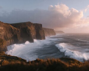 Fototapeta premium Dramatic high cliffs overlooking ocean waves at sunset for nature travel background, majestic coastal scenery with soft mist and breaking surf for atmospheric landscape
