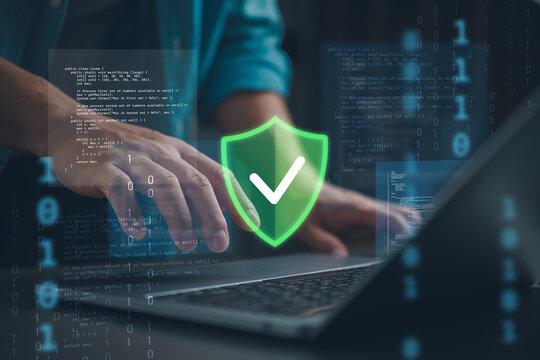 Cybersecurity protection concept with secure shield icon over laptop and source code. Data security, encryption, privacy protection and network defense for safe digital technology and IT systems.