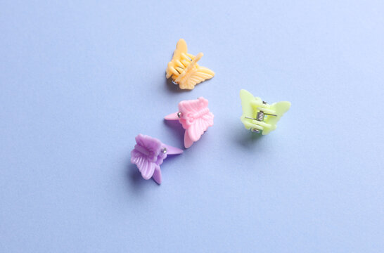 Butterfly-shaped hair clips on a blue background