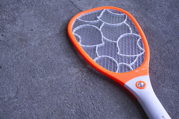 Top View Electric Mosquito Swatter on Textured Concrete Surface, Minimalist Household Pest Control Concept Background