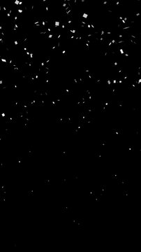 Falling explotion shiny white confetti isolated on transparent video black vertical background. Bright festive tinsel of silver color.