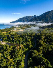 Naklejka premium Aerial view of a lush landscape with a winding road