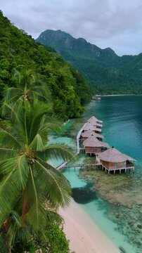 Stunning Ora Beach with Overwater Cottages in Sawai Saleman, Central Maluku, Indonesia. Exotic tropical landscape of Ora Beach located in Sawai Saleman, Central Maluku, Indonesia