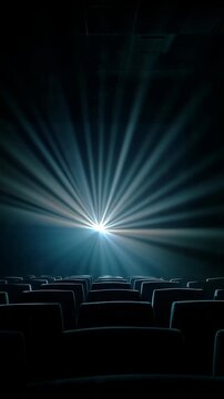 Empty cinema seats illuminated by a bright projector beam